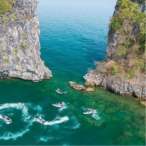 Three men skillfully maneuvering a jet ski through the sparkling ocean waters, experiencing an exhilarating and dynamic ride.