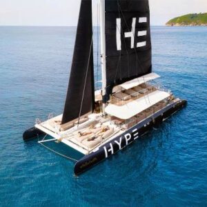 A catamaran featuring the word "hype" prominently displayed on its side, sailing on calm waters under a clear sky.