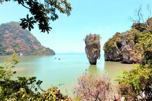 Majestic rock formations rising from the ocean, highlighting their impressive height and rugged beauty at James Bond Island.