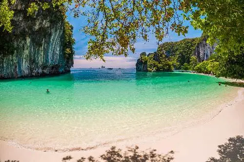 Tranquil Koh Yao Yai beach with turquoise waters meeting pristine white sand in Thailand.