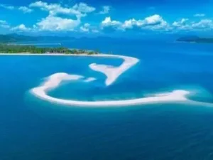 Atemberaubende Luftaufnahme einer herzförmigen Insel, umgeben von lebendigem blauen Wasser, das Liebe und Ruhe symbolisiert, in der Nähe von Koh Yao Yai Island.