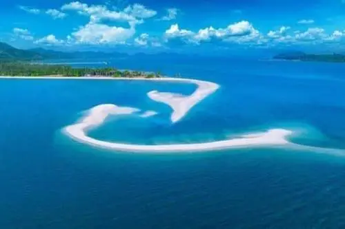 A stunning aerial view of a heart-shaped island, nestled in vibrant blue waters, symbolizing love and serenity.