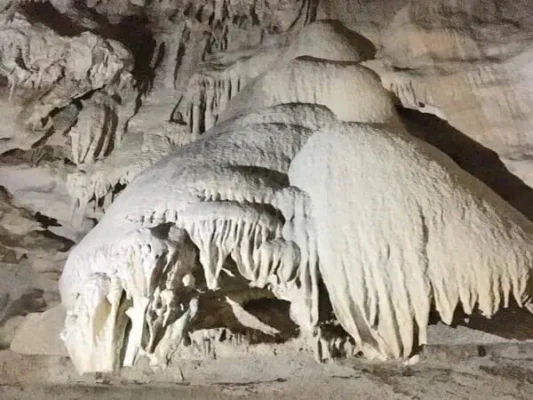 Innerhalb einer Höhle erheben sich große weiße Formationen dramatisch und schaffen eine fesselnde unterirdische Landschaft.