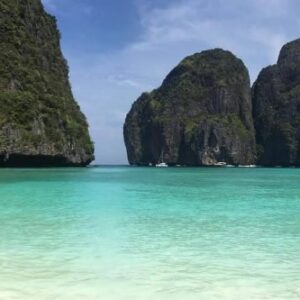 Scenic view of Maya Bay in Thailand, showcasing its stunning turquoise waters and lush green cliffs, perfect for stock footage.