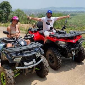 Two people enjoying an ATV ride in the mountains, illustrating the spirit of adventure amidst stunning natural scenery.