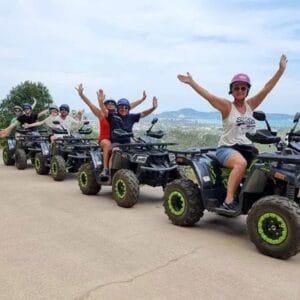 Four people on ATVs exploring a scenic jungle road, perfect for adventure seekers.