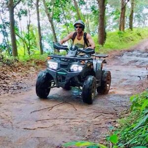 A man skillfully maneuvers an ATV along a dirt road, highlighting the spirit of adventure in the great outdoors.