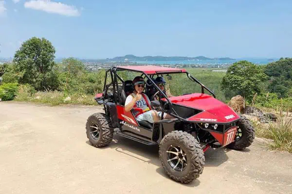 Ein Mann und eine Frau genießen gemeinsam eine abenteuerliche Fahrt in einem lebendigen roten UTV und erleben Spaß und Kameradschaft in der Natur.