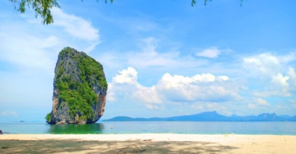 A stunning view of Poda Island, Thailand, showcasing its lush greenery and crystal-clear waters under a bright blue sky.