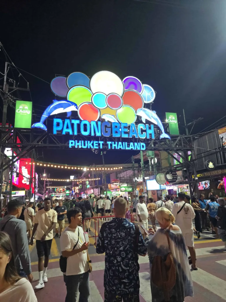 Eingang zur Bangla Road von der Beach Road aus mit Neonlichtern und belebten Bars bei Nacht.