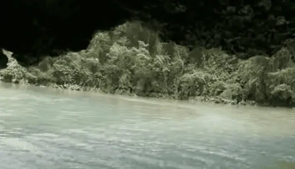 Family paddling through limestone caves in Phang Nga Bay.