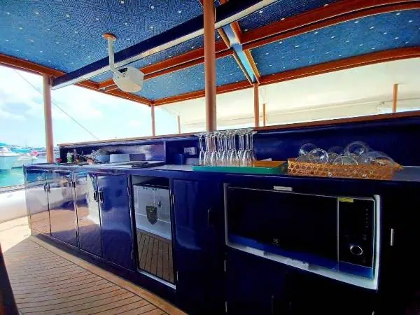 A sleek boat kitchen with blue and white cabinets, blending nautical charm and modern design, ideal for a luxurious Coral Island catamaran tour.