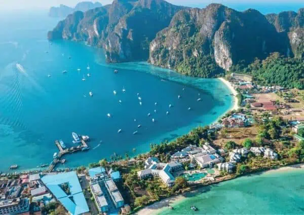 A scenic collage highlighting Thailand's top tourist spots, featuring stunning beaches, iconic temples, and bustling cityscapes from a boat tour to Phi Phi Island.