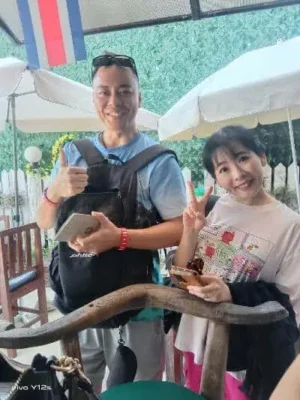 Chinesisches Pärchen in einem Restaurant mit Aussicht auf Phuket, nachdem sie bei TIP Tourinformation Phuket einen Motorroller gemietet haben.