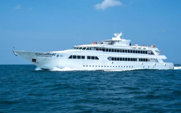 A large white yacht sailing in the ocean near Ao Nang, with a ferry in the background, showcasing the beauty of Phuket.