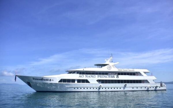 A white yacht gracefully floats on the serene ocean waters under a clear blue sky.