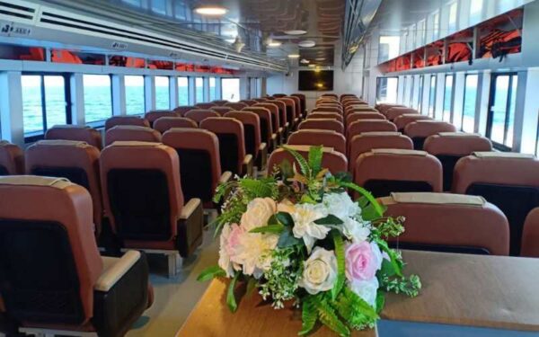 Interior of a ferry in Ao Nang, Phuket, featuring a table adorned with vibrant flowers.