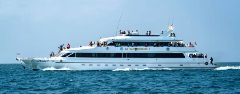 A large white ferry in Phuket, carrying passengers as they enjoy a scenic boat ride across the turquoise waters.