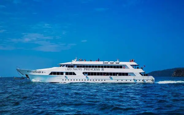 A large white ferry navigating the calm ocean waters near Ao Nang, Phuket, with a peaceful maritime scene in the background.