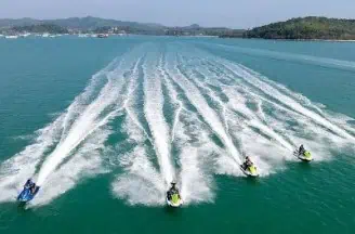 A group enjoying an exhilarating jet ski ride across vibrant blue ocean waters, showcasing the excitement of water sports in paradise.