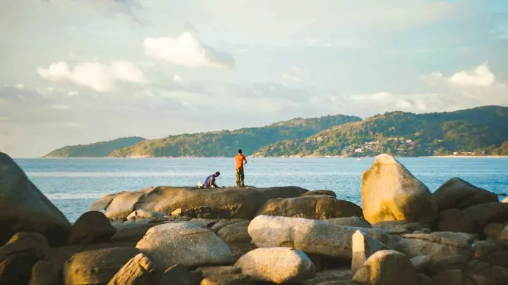 Kalim Beach in northern Phuket with clear water, ideal for swimming, snorkeling, and sunbathing.