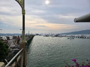 Ao Chalong Pier in Phuket with many sailboats in the harbor and a picturesque view of the sea.