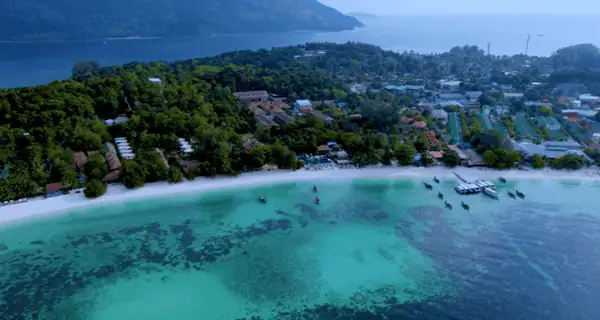 Tranquil beach on Koh Lanta with palm trees and blue sea.