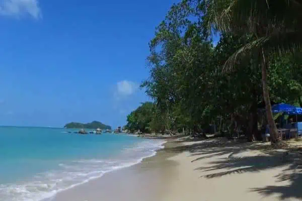 View of Laem Singh Beach with sandy shores, jungle, and cliffs, a hidden Phuket gem.