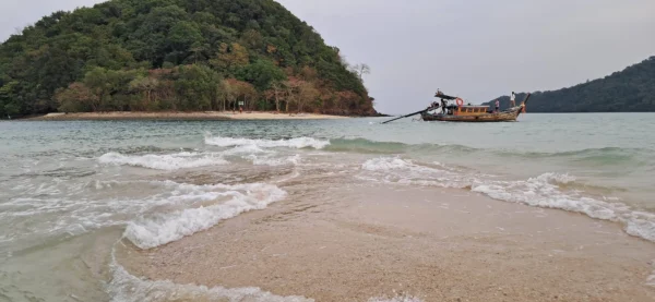 Die Gezeiten legen eine Sandbank vor einer kleinen Insel frei