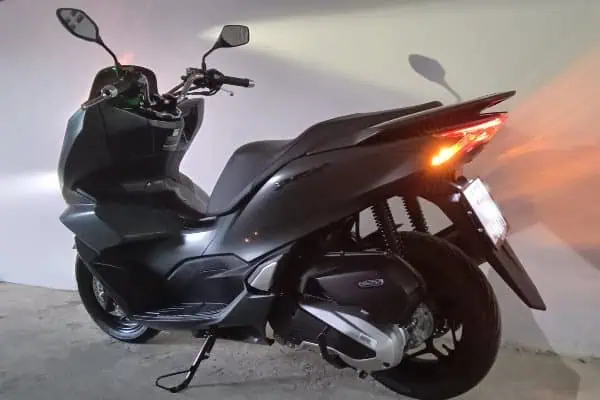 Black Honda PCX 160 scooter parked in a garage in Phuket, available for rent at TIP Tourinformation Phuket.