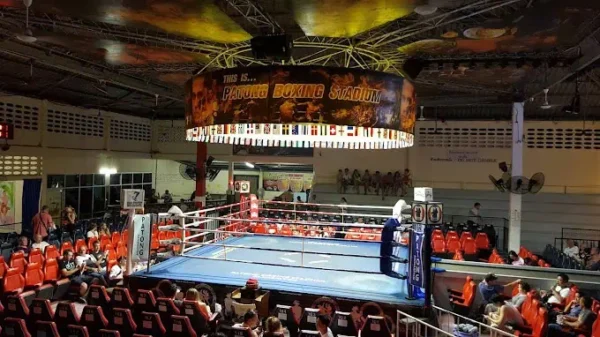 Patong Boxing Stadium: Zwei Kämpfer liefern sich einen spannenden Kampf im Ring, umgeben von begeisterten Zuschauern.