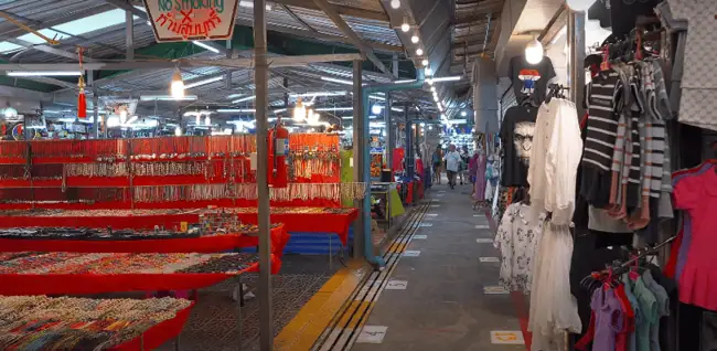 family browsing colorful stalls at Naka Weekend Market in Phuket.
