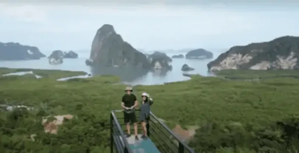 Couple taking selfie on viewpoint pier overlooking Phang Nga Bay in Thailand.