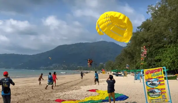 Person parasailing above Patong Beach.