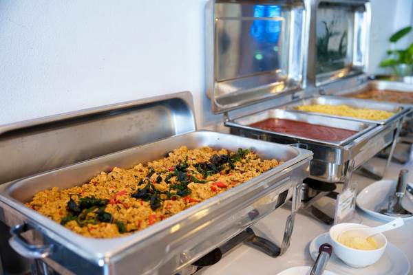 A buffet line featuring an array of plates and bowls filled with various dishes for guests to choose from.