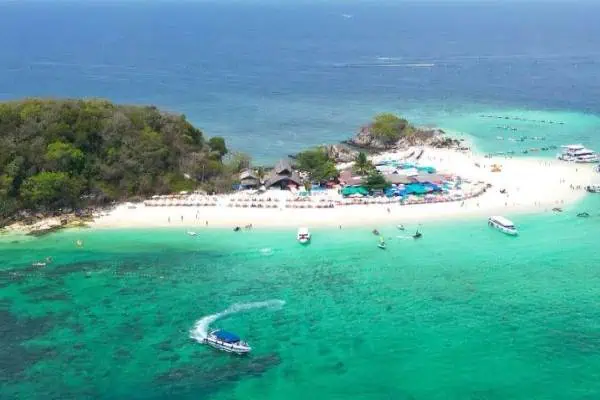 Scenic aerial shot of a beach filled with boats and sunbathers, showcasing the lively atmosphere of a coastal area, ideal for a Phi Phi Island tour.