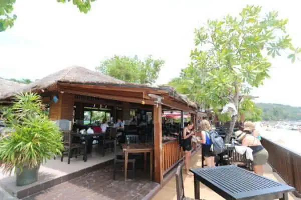 A picturesque beach bar at Khai Island, surrounded by palm trees, offering stunning ocean views and a relaxing atmosphere.