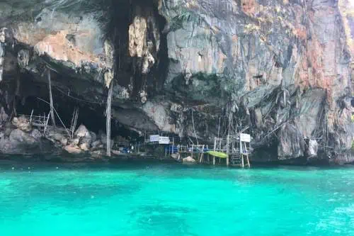 A stunning view of the cave at Phi Phi Island, showcasing its rocky formations and crystal-clear waters.