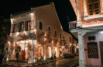 Illuminated Soi Romani Street in Phuket City at night, showcasing vibrant lights, bustling nightlife, and lively atmosphere.