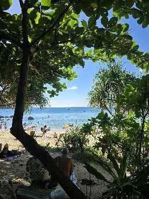 Relaxing at the tranquil Banana Beach with no sunbeds or umbrellas, surrounded by clear waters and smooth sand.