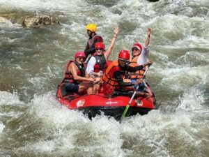 A group of individuals navigating a river in an inflatable raft, enjoying an adventurous outdoor experience.