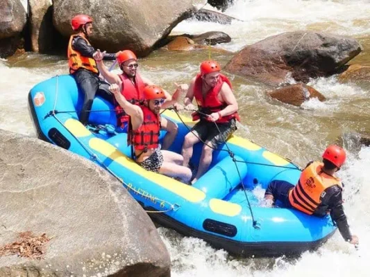 A group of people paddling together in an inflatable raft on a river, enjoying a day of outdoor adventure.