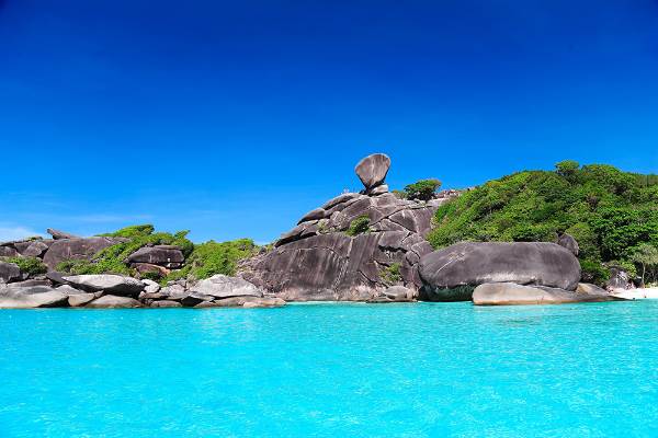 A captivating view of Aman Island in Thailand, emphasizing its scenic beauty with lush greenery and clear blue waters.