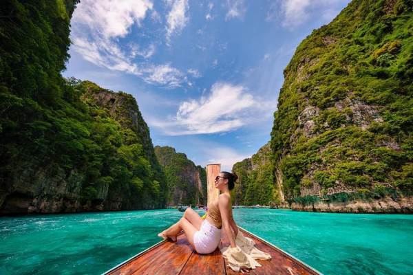 A woman aboard a boat, immersed in the beauty of the expansive blue ocean.