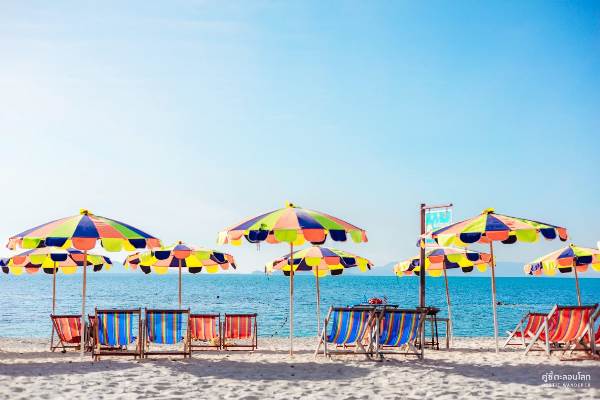 A collection of colorful umbrellas on the beach, adding a cheerful touch to the sunny coastal landscape.