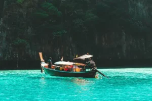 A boat peacefully floating in the bright turquoise waters of a beautiful tropical island setting.