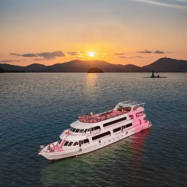 A pink and white boat gently floating in the ocean, creating a serene and picturesque scene, perfect for a romantic dinner cruise into the sunset.