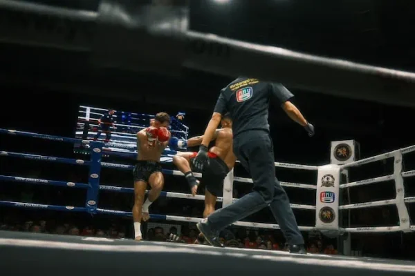 Muay Thai Tickets: Ein aufregender Boxkampf mit Schiedsrichter und zwei engagierten Kämpfern im Ring.