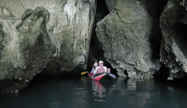 Canoe under limestone cliff at James Bond Island in Phang Nga Bay Thailand.