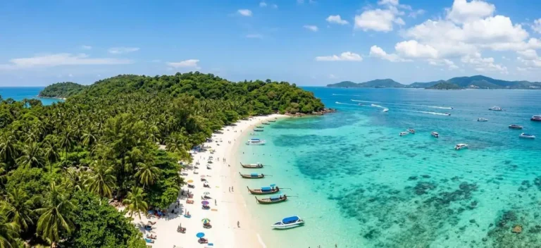 Coral Island vor Phuket: türkises Wasser, weißer Sandstrand, Palmen, Speedboote in der Ferne